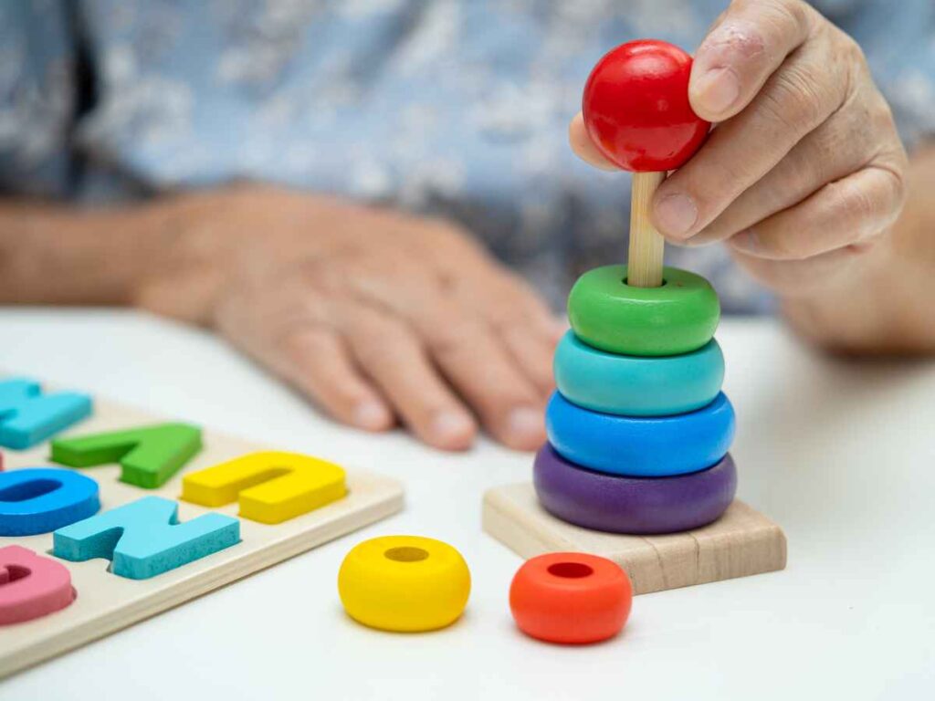 Blog image 1 which shows a patient using a colourful building block with their hands. You cannot see the persons face or gender.