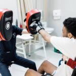 Patient practicing boxing exercises during neurorehabilitation, illustrating neuroplasticity exercises for spinal cord injury recovery and improved motor control.